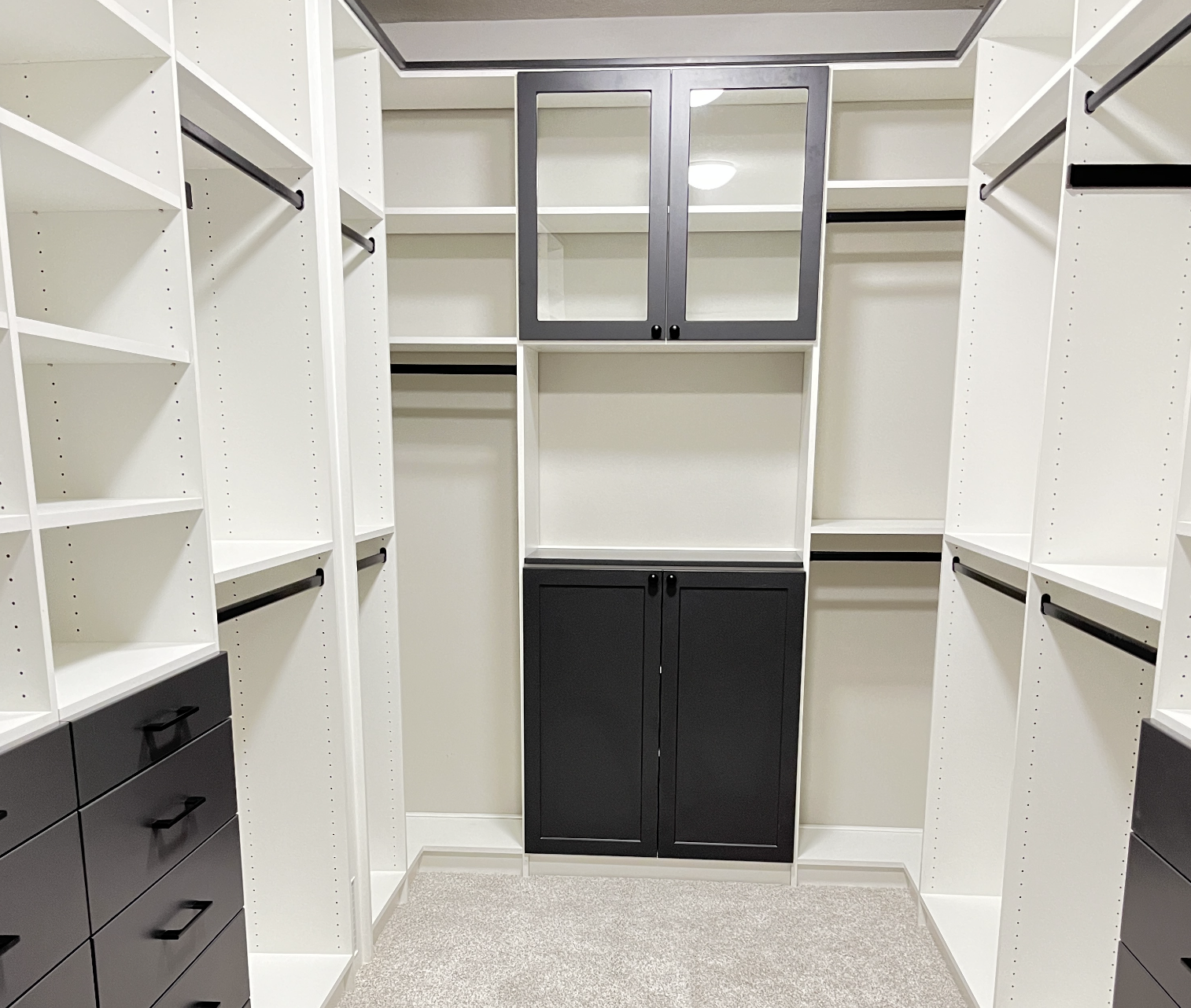 Clean white and beige closet with a decorative stool and tan blazers hanging