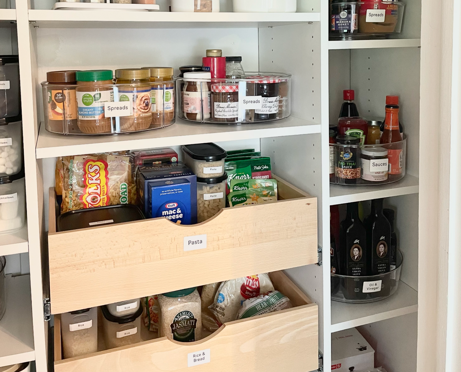Organized metal storage racks with various clear plastic storage bins with labels